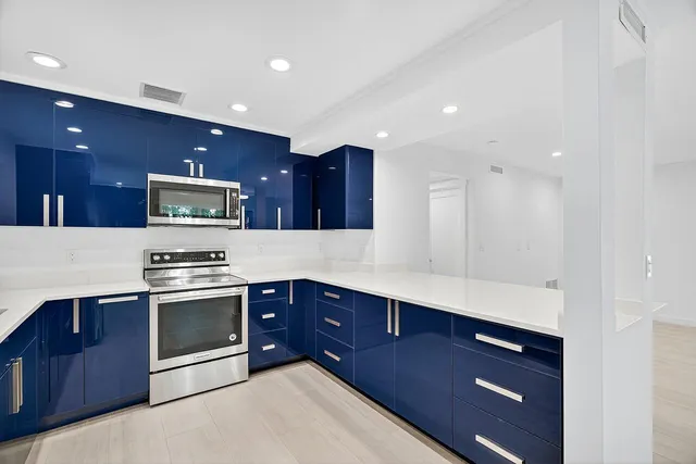 a kitchen with stainless steel appliances granite countertop wooden cabinets a stove top oven and a sink