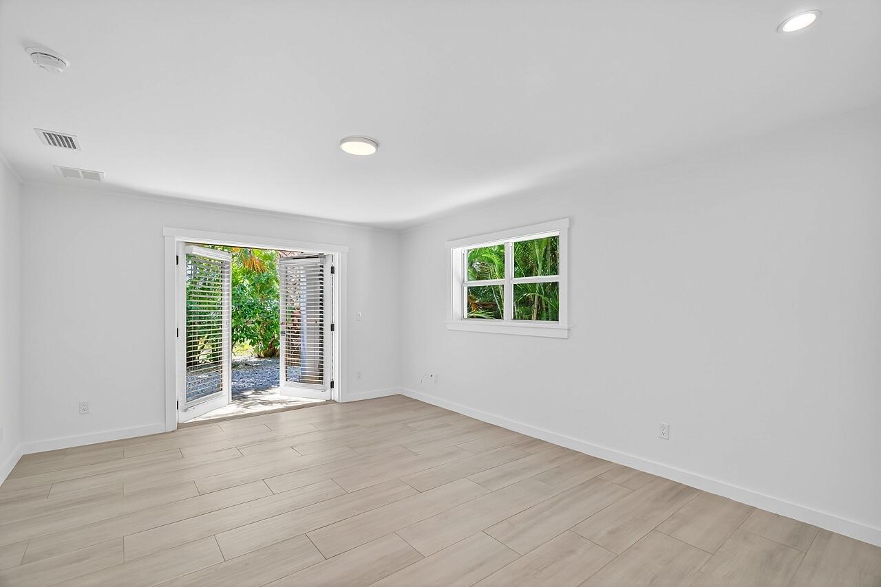 924 Coquina Lane, Unit 3 Vero Beach, FL 32963 - Photo 24 of 44 an empty room with wooden floor and windows