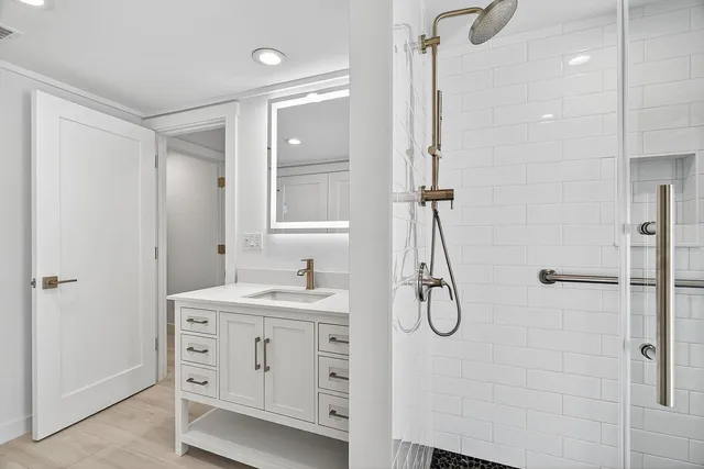 a bathroom with a granite countertop sink a shower and a mirror