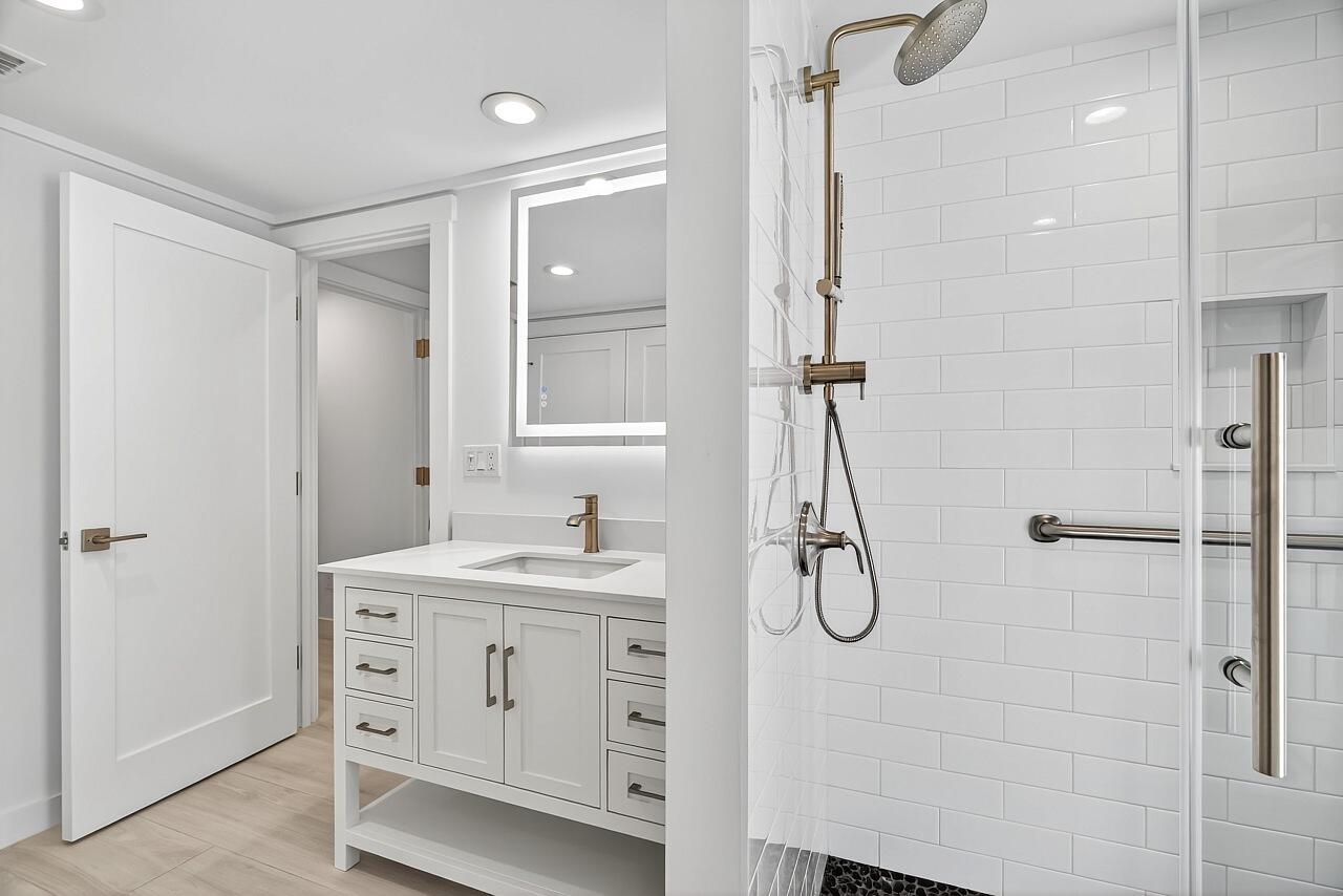 924 Coquina Lane, Unit 3 Vero Beach, FL 32963 - Photo 30 of 44 a bathroom with a granite countertop sink a shower and a mirror
