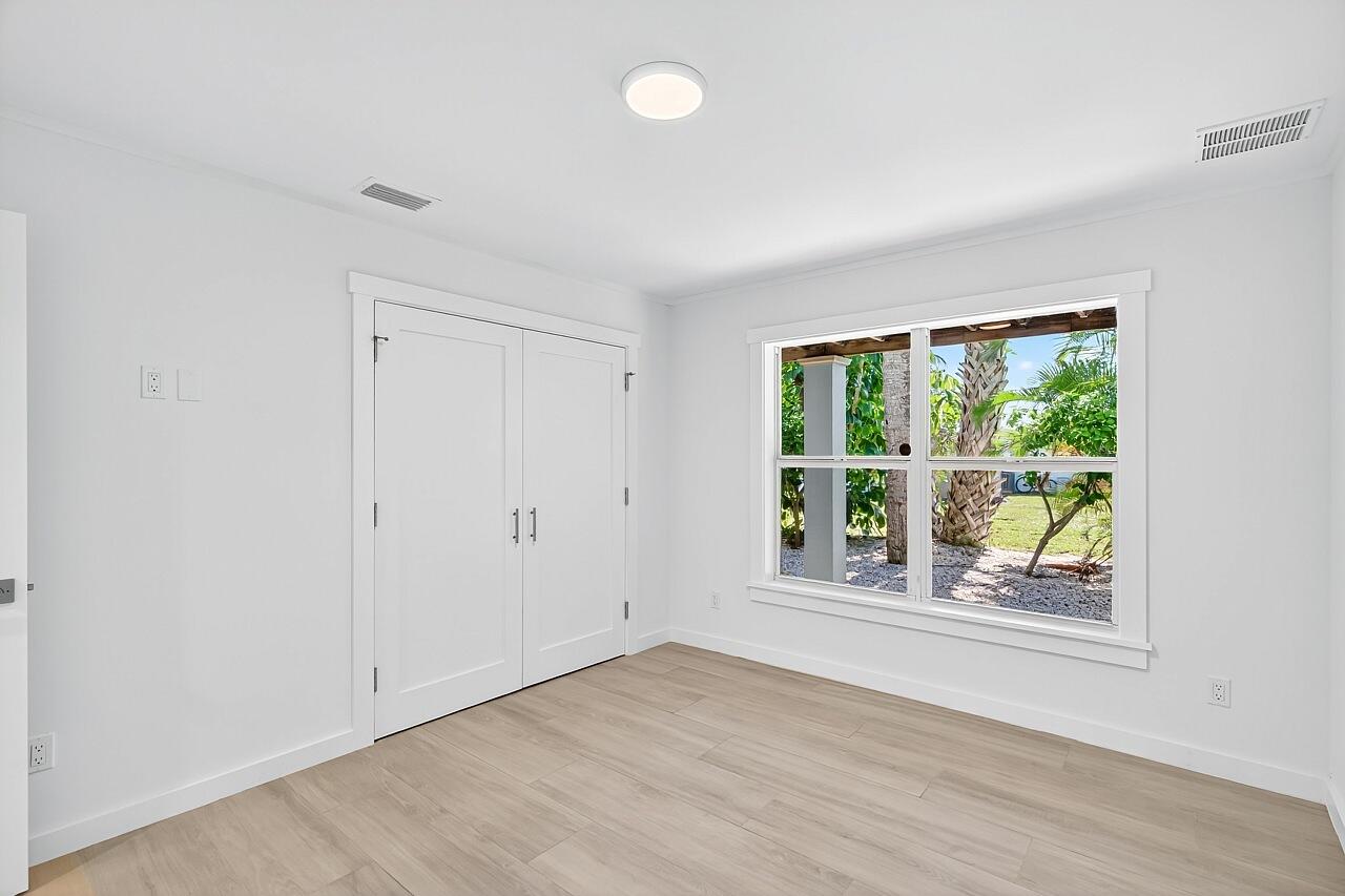 924 Coquina Lane, Unit 3 Vero Beach, FL 32963 - Photo 35 of 44 an empty room with wooden floor and windows