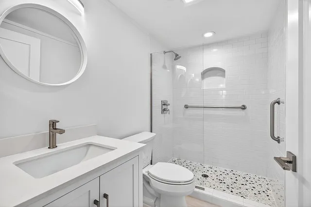 a bathroom with a sink a toilet and shower