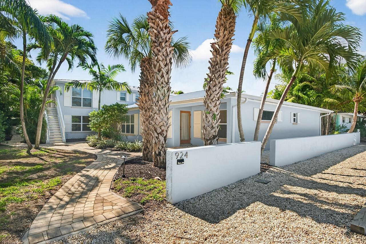 924 Coquina Lane, Unit 3 Vero Beach, FL 32963 - Photo 43 of 44 a view of a white house with a yard and palm trees