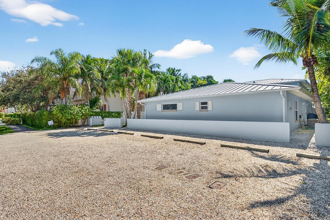 924 Coquina Lane, Unit 3 Vero Beach, FL 32963 - Photo 44 of 44 a front view of a house with a yard and a garage