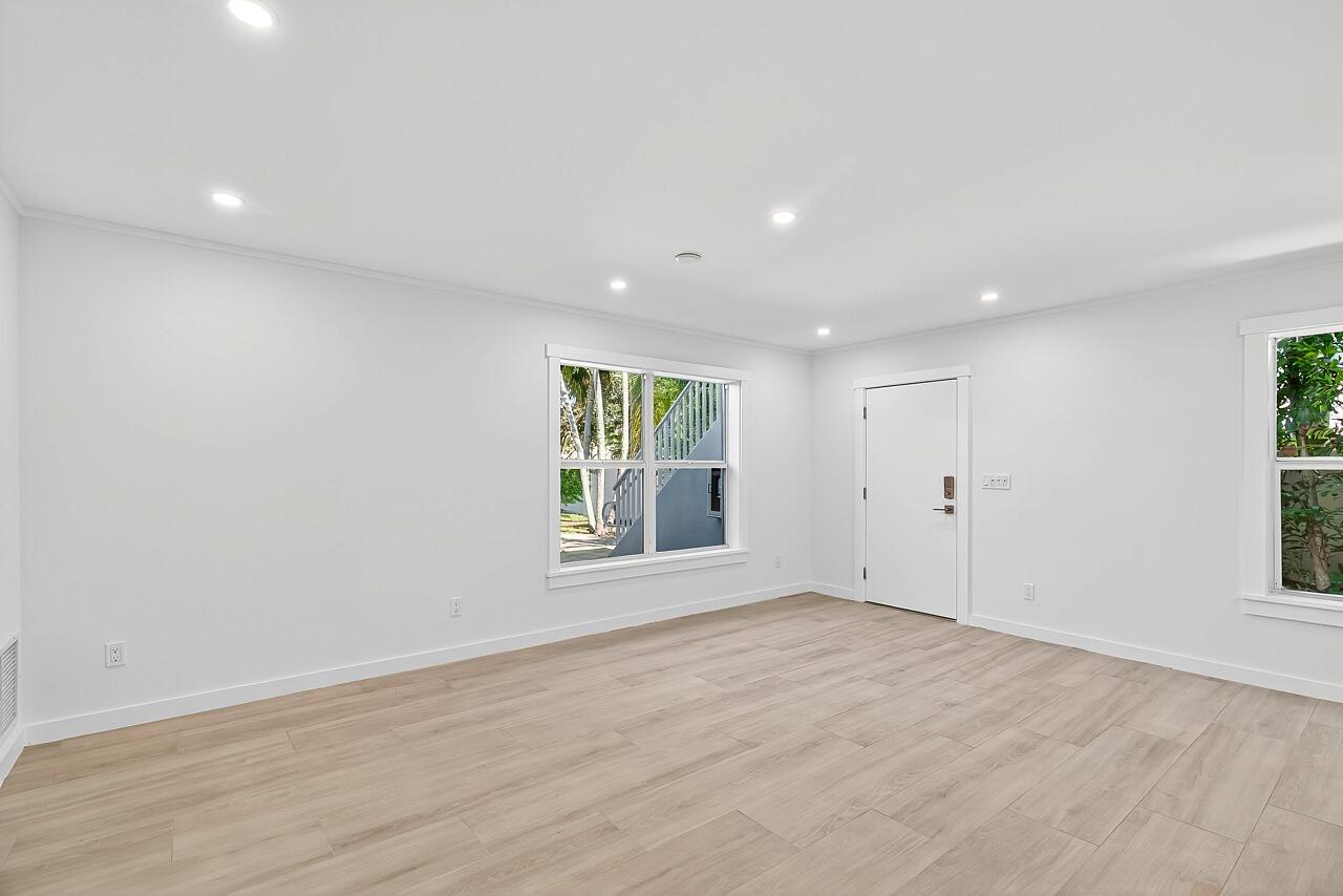 924 Coquina Lane, Unit 3 Vero Beach, FL 32963 - Photo 5 of 44 an empty room with wooden floor and windows