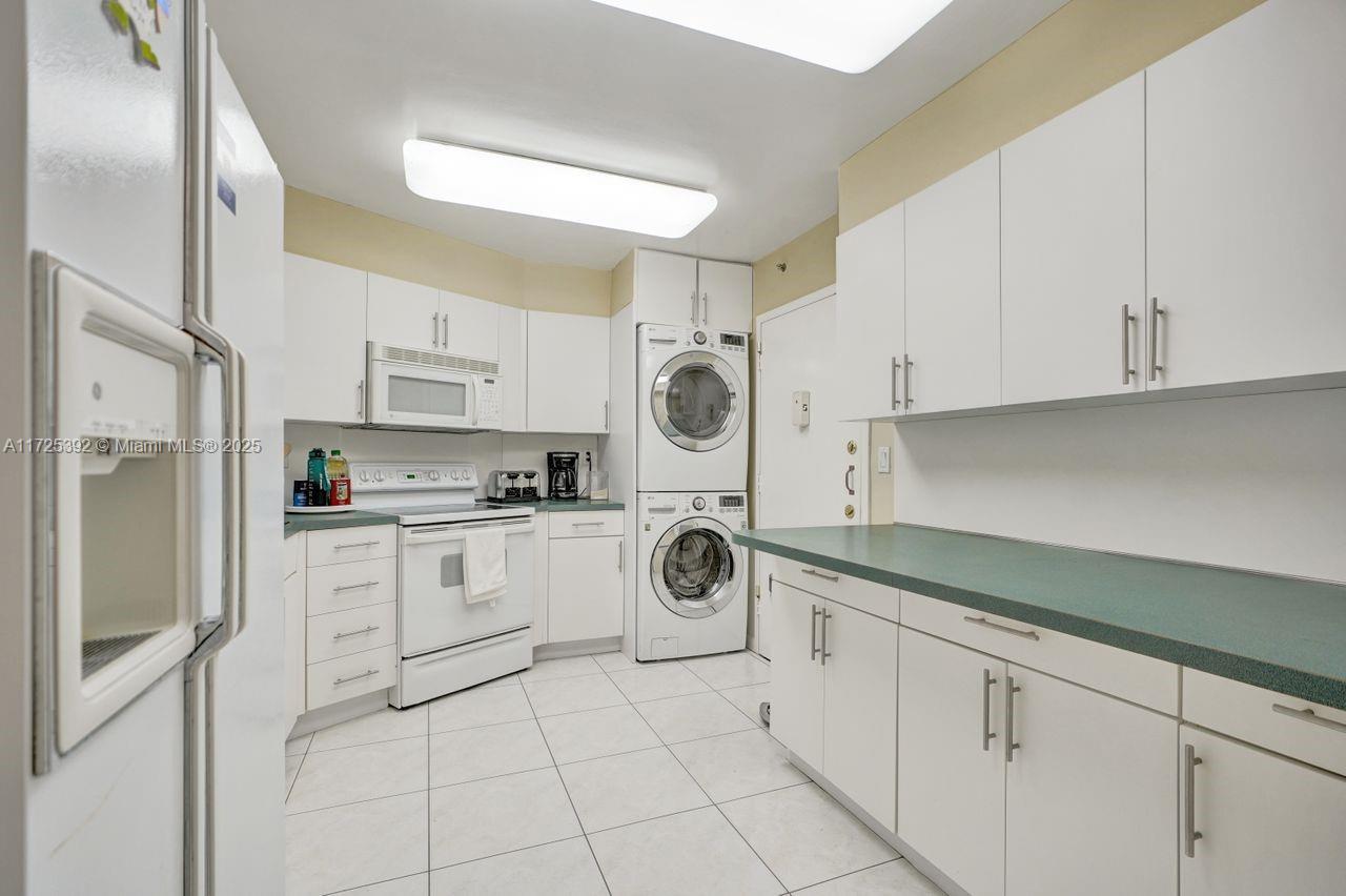1111 Crandon Boulevard, Unit C804 Key Biscayne, FL 33149 - Photo 13 of 25 a kitchen with white cabinets and white appliances