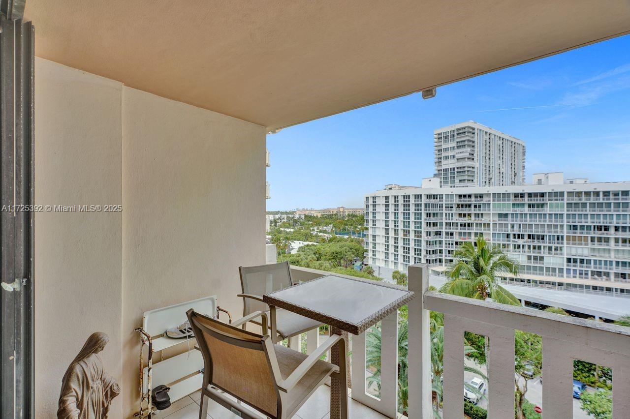 1111 Crandon Boulevard, Unit C804 Key Biscayne, FL 33149 - Photo 3 of 25 a view of a balcony with table and chairs and wooden fence