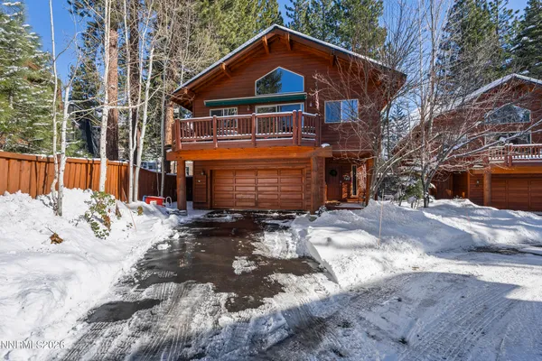 a front view of a house with a yard covered with snow in front of house
