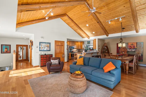 a living room with furniture a rug and kitchen view