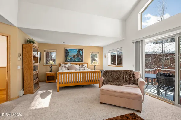 a bedroom with a bed and a couch with large window