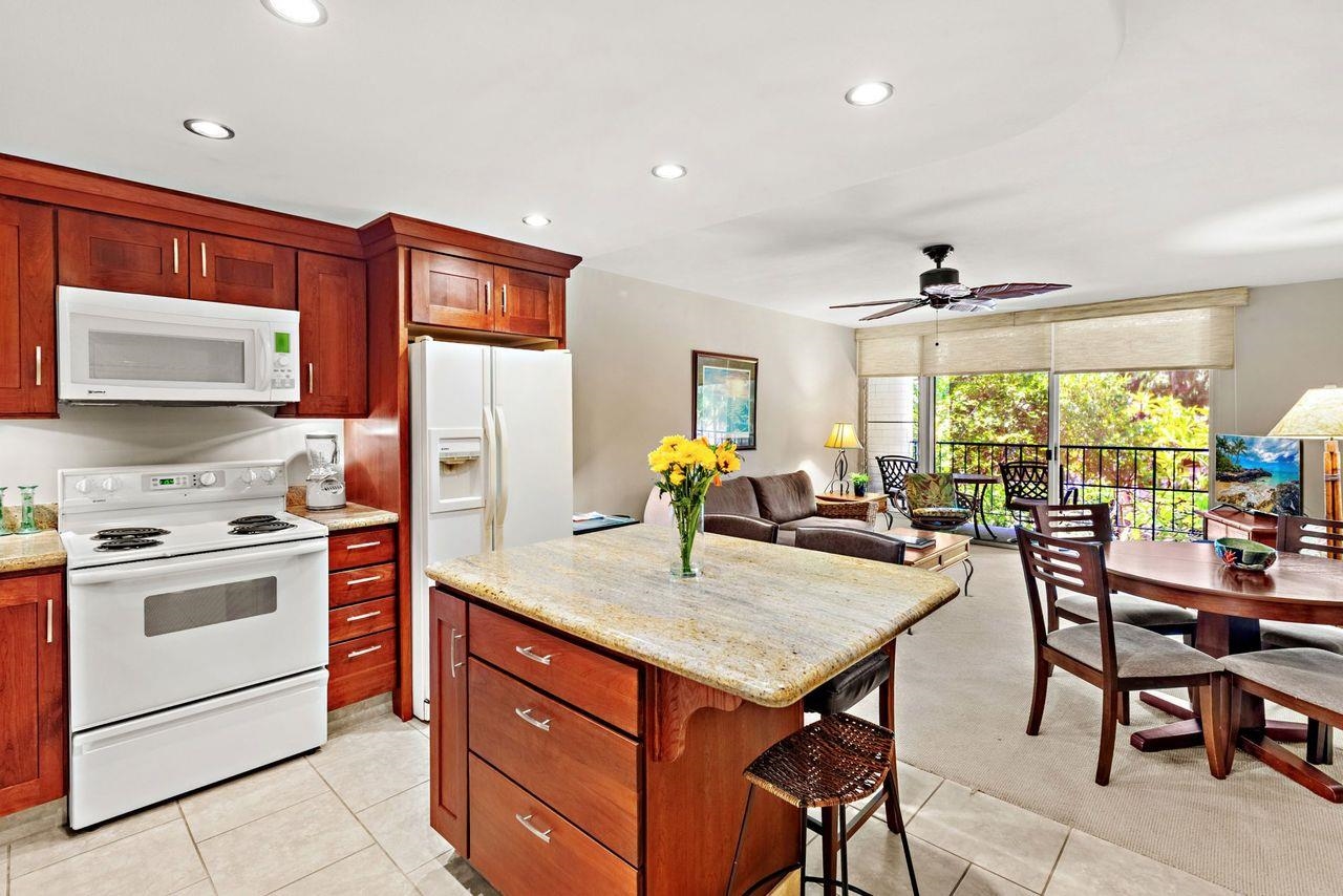 3750 Lower Honoapiilani Road, Unit 202 Lahaina, HI 96761 - Photo 1 of 22 a kitchen with a stove a refrigerator and a dining table