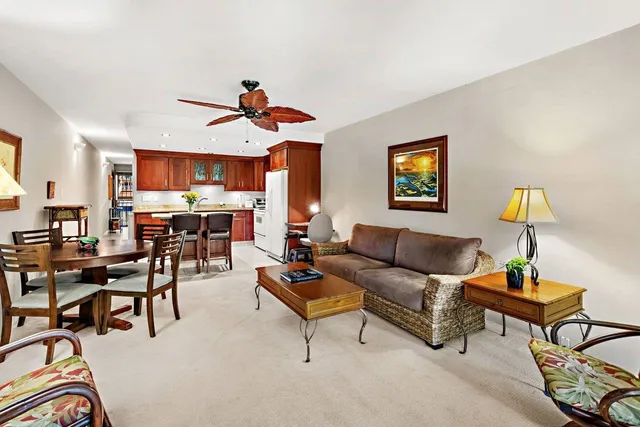 a living room with furniture kitchen view and a lamp