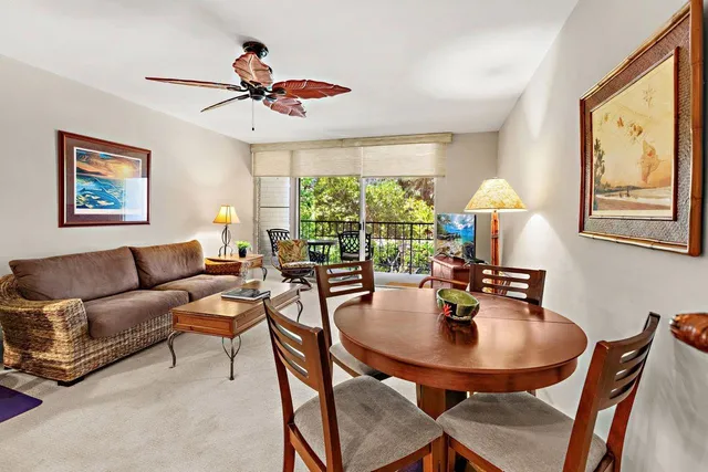 a dining room with furniture a large window and a chandelier