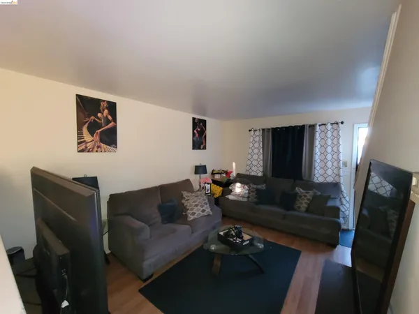 a living room with furniture a rug and a flat screen tv