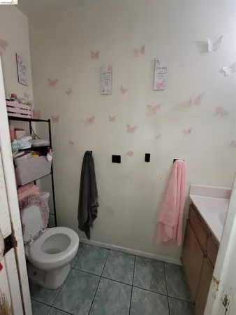 a white toilet sitting next to a sink and vanity