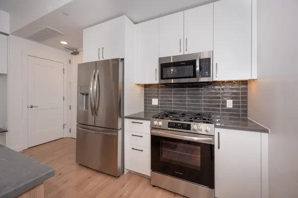 a view of empty room with wooden floor