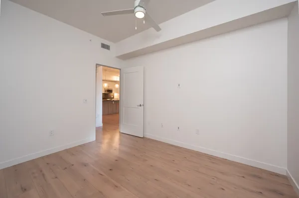 an empty room with wooden floor and windows