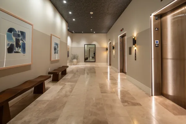 a view of a hallway with wooden floor and a living room