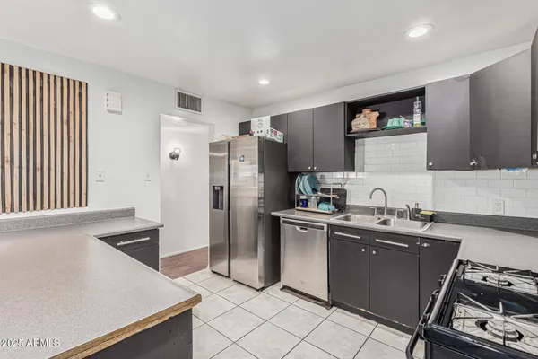 a kitchen with stainless steel appliances granite countertop a refrigerator and a stove top oven