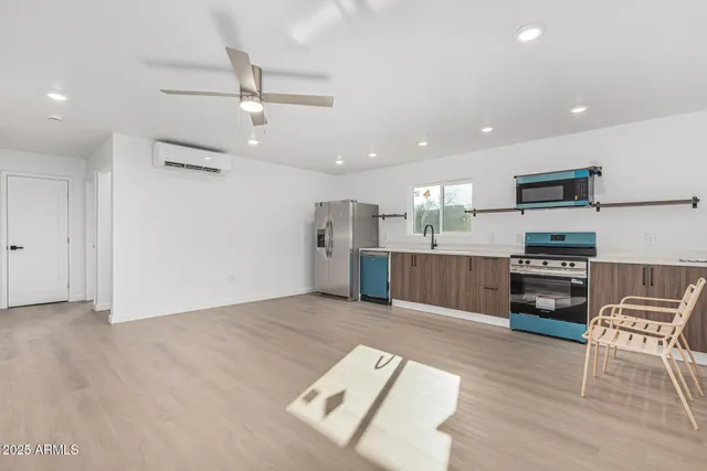 a kitchen with stainless steel appliances kitchen island granite countertop a stove and a refrigerator