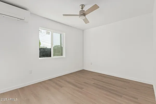 an empty room with a window and a ceiling fan