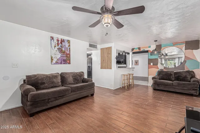 a living room with furniture and a wooden floor