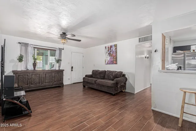 a living room with furniture and a wooden floor