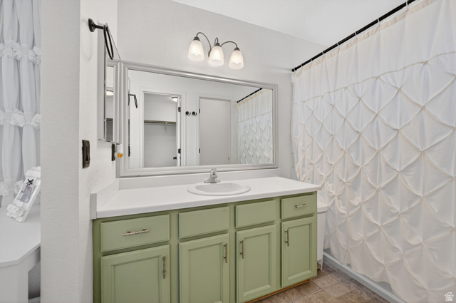 2190 West 1450th Street North Layton, UT 84041 - Photo 11 of 11 Bathroom featuring a single vanity with a mint green cabinet base, a white countertop, and a basin sink