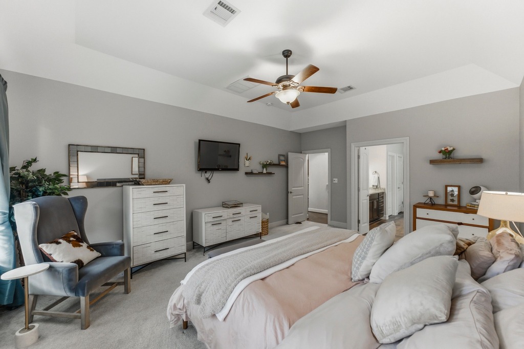 5425 Cherokee Draw Road Austin, TX 78738 - Photo 20 of 40 Relax in a generously proportioned sleeping area, featuring a tray ceiling and plush carpeted flooring.