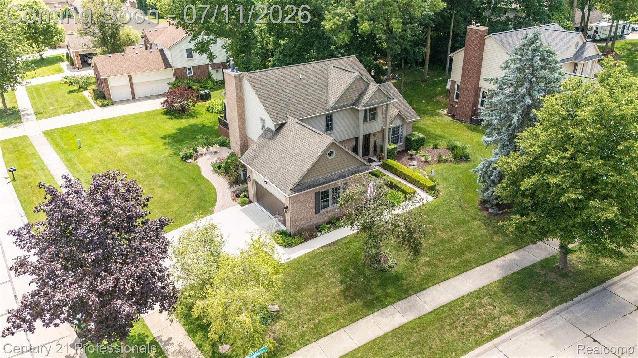 689 Woodfield Way Rochester, MI 48307 - Photo 57 of 61 Colonial-style residence featuring a brick facade, multi-gabled roofline, attached garage, and a concrete driveway