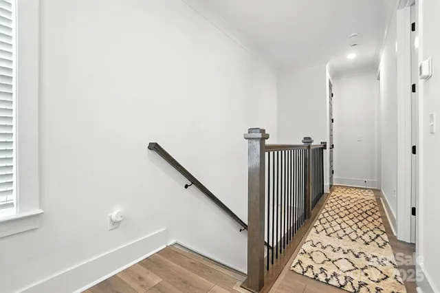 a view of a hallway with wooden floor and staircase