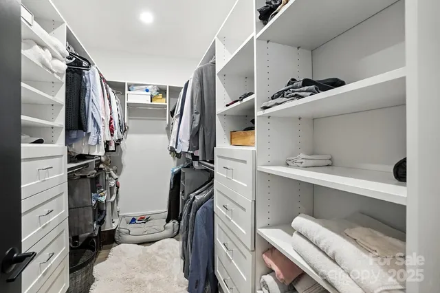 a view of walk in closet with clothes and shoes