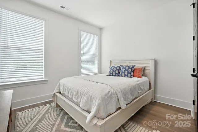 a large bed sitting in a bedroom next to a window