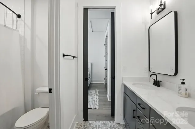 a bathroom with a granite countertop sink toilet and shower