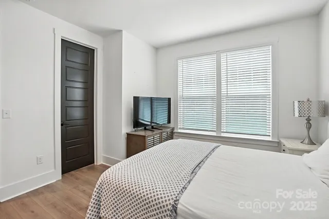 a bedroom with a bed and a flat tv screen on a dresser