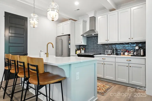 a kitchen with stainless steel appliances granite countertop a sink a stove a refrigerator and cabinets