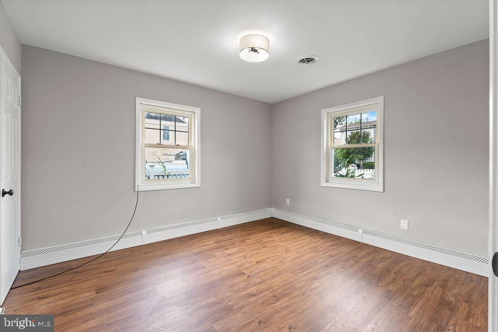 38 4th Street Laurel, MD 20707 - Photo 11 of 27 an empty room with wooden floor and windows