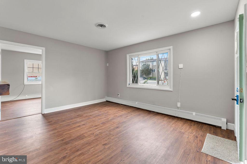 38 4th Street Laurel, MD 20707 - Photo 14 of 27 an empty room with wooden floor and windows