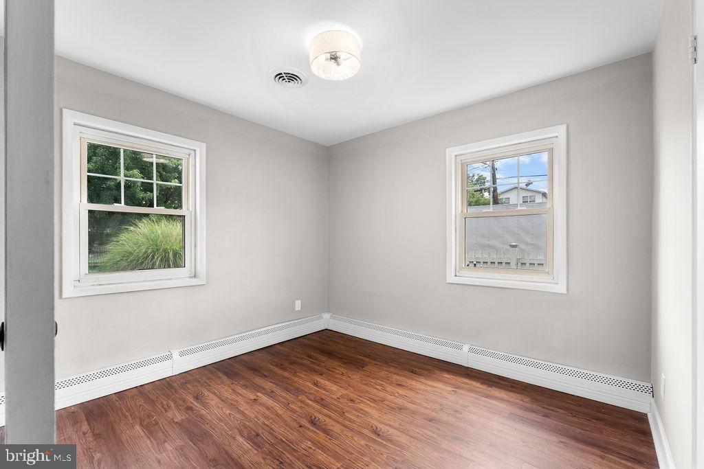 38 4th Street Laurel, MD 20707 - Photo 17 of 27 an empty room with a window and wooden floor