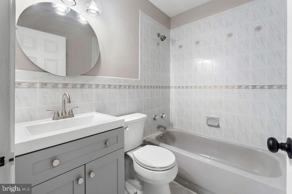38 4th Street Laurel, MD 20707 - Photo 19 of 27 a bathroom with a sink a toilet and a mirror