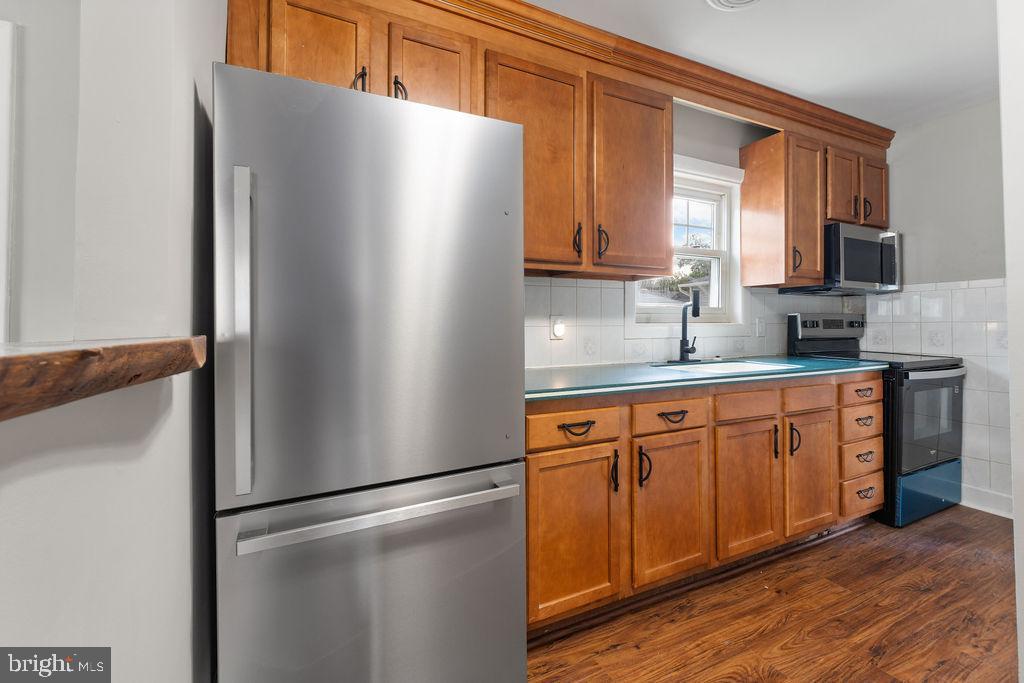 38 4th Street Laurel, MD 20707 - Photo 2 of 27 a kitchen with stainless steel appliances granite countertop a refrigerator and a sink