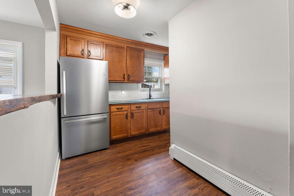 38 4th Street Laurel, MD 20707 - Photo 4 of 27 a kitchen with a refrigerator a sink and wooden floor