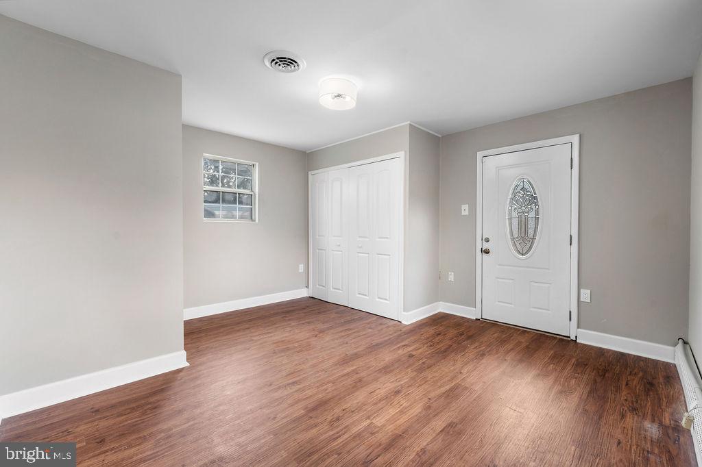 38 4th Street Laurel, MD 20707 - Photo 8 of 27 an empty room with wooden floor and mirror
