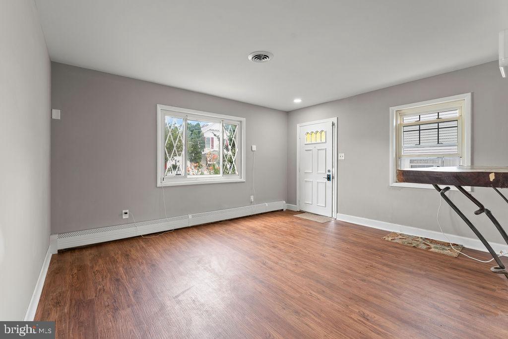 38 4th Street Laurel, MD 20707 - Photo 9 of 27 an empty room with wooden floor and windows