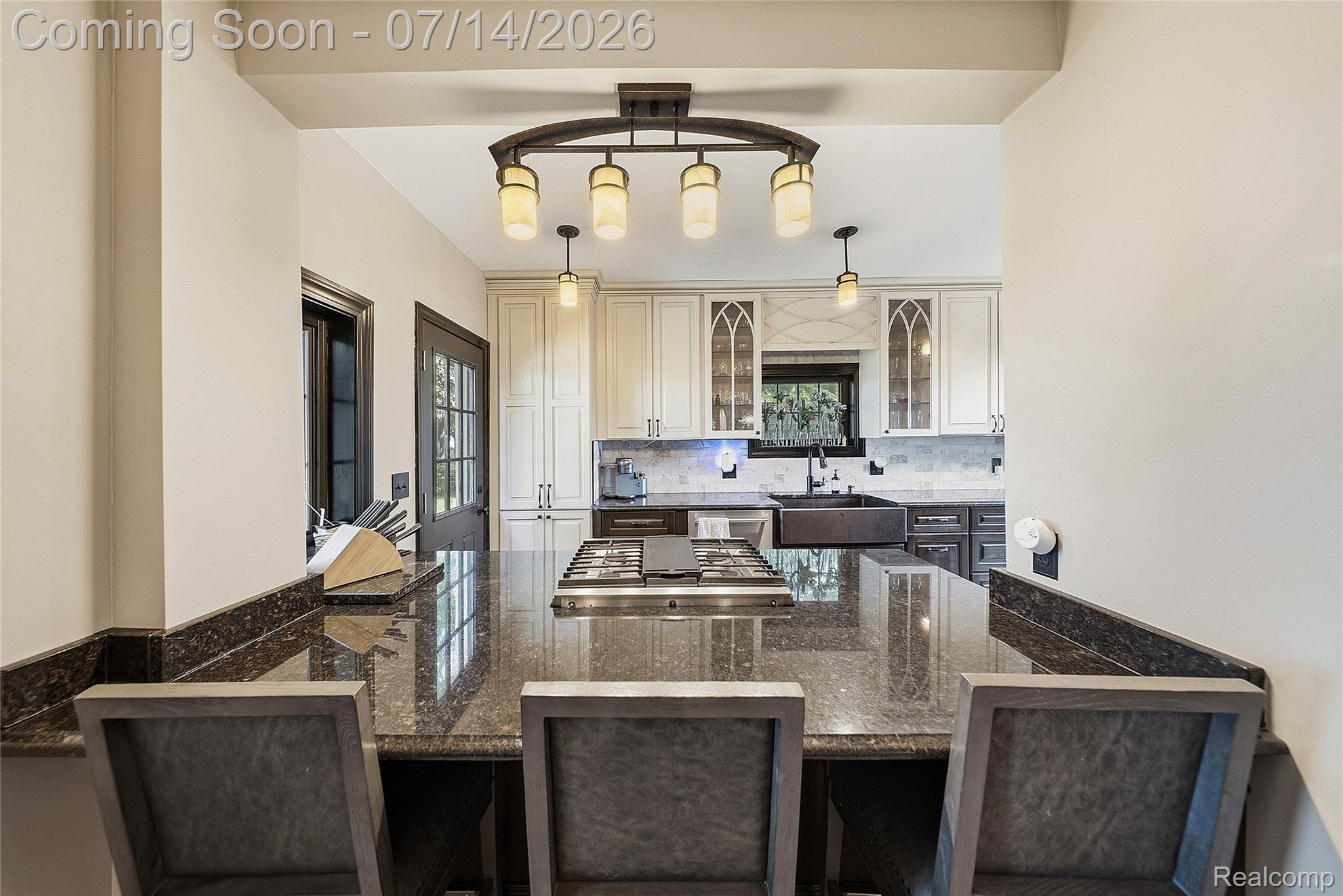 18460 Meridian Road Grosse Ile, MI 48138 - Photo 21 of 50 Kitchen island featuring a built-in gas cooktop, polished stone countertop, and integrated breakfast bar