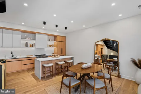 a large kitchen with stainless steel appliances a large counter top a stove and a refrigerator