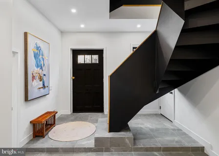 a kitchen with stainless steel appliances kitchen island granite countertop a stove a refrigerator a dining table and chairs with wooden floor