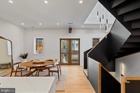 a kitchen with stainless steel appliances granite countertop a table chairs and a refrigerator