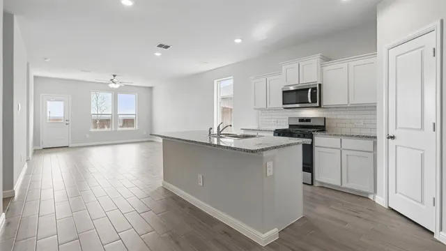 a kitchen with stainless steel appliances granite countertop a sink and stove