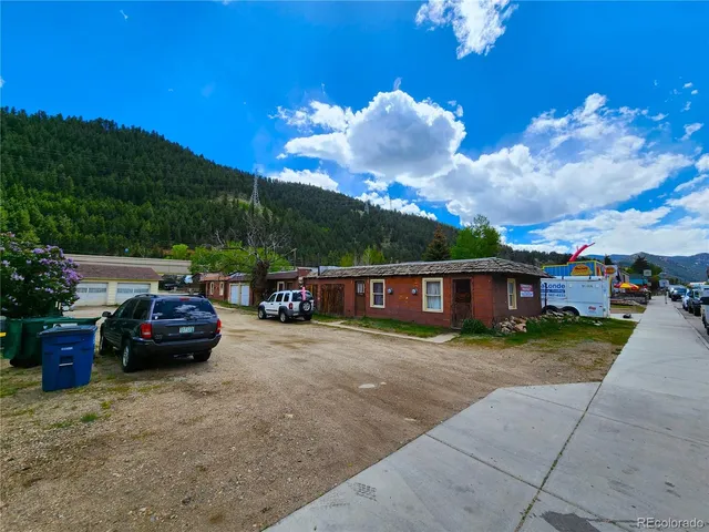 a sign that is sitting in front of a house with yard